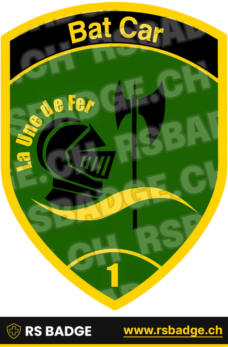 Ein Armee Militär-Badge, das eine Schildform mit einem grünen Hauptfeld aufweist, wo ein schwarzes Ritterhelm mit der Inschrift „La une de fer“ auf der einen Seite und der schwarzen Zeichen eines Wikingerspieß auf die andere Seite dargestellt. Der Hintergrund wird in hellgrün und schwarz gehalten. Das Emblem ist schildförmig mit einem schwarzen Banner oben mit der Aufschrift „Bat Car“ und der Zahl „1“ unten in grün.